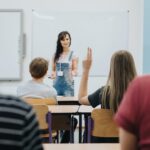 Teacher standing in front of the class room full of teenage students